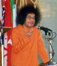 Sathya Sai Baba em pé diante dos microfones